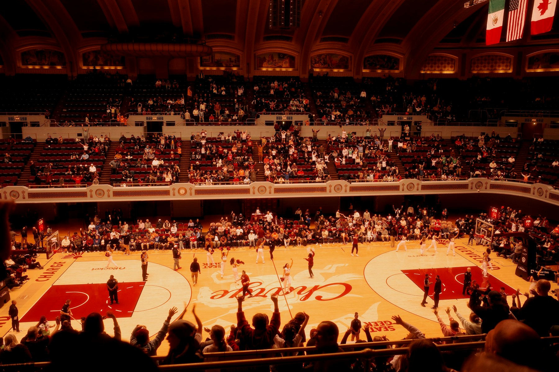 Fans celebrating inside a brightly lit sports venue during a high-energy night game